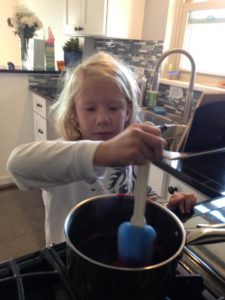 Cooking wild huckleberries to make homemade syrup