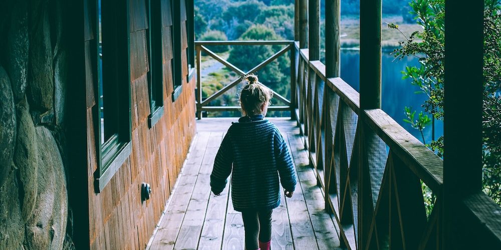 child walking along a homestead cabin