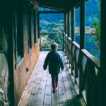 child walking along a homestead cabin