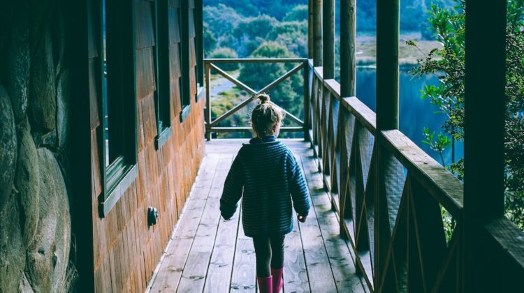 child walking along a homestead cabin