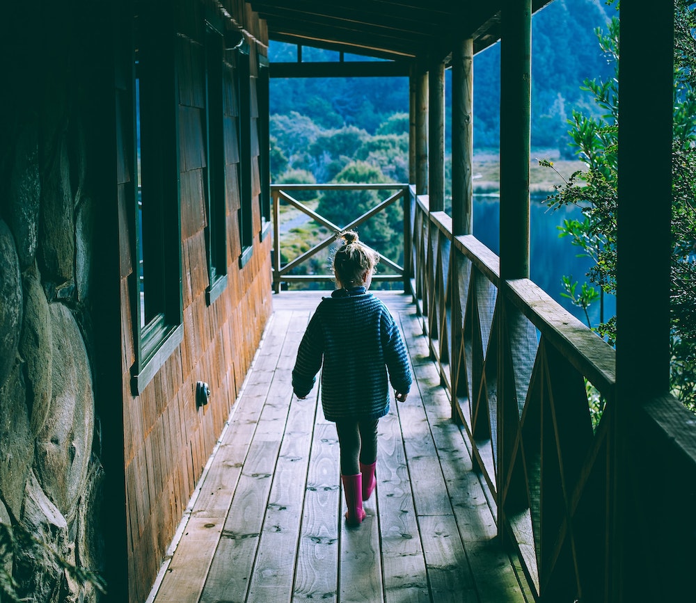 child walking along a homestead cabin