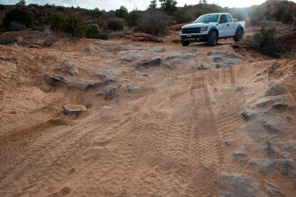 A 4x4 truck begins to cross rugged terrain at Arches National Park