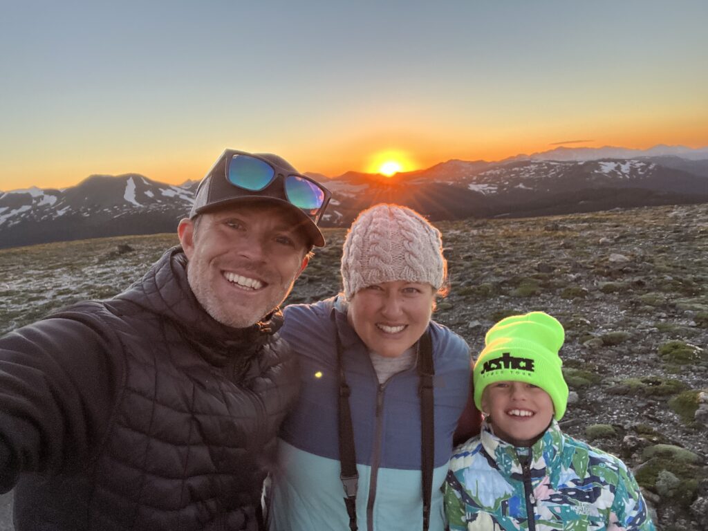 A family poses for a mountain sunset at Rocky Mountain National Park